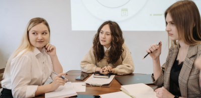 3 Young Professional Women Sitting Around a Conference Table
